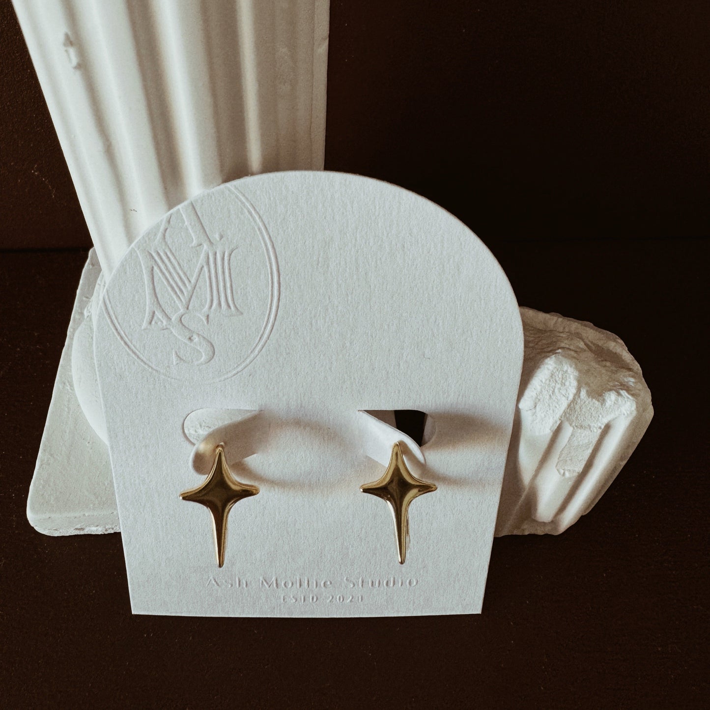 Gold hoop earrings with starburst design and polished finish