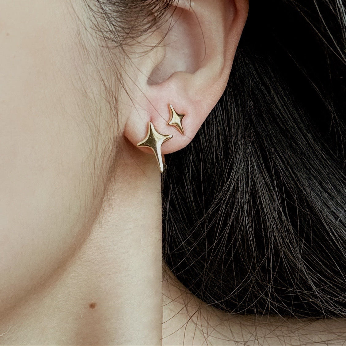 Gold hoop earrings with starburst design and polished finish