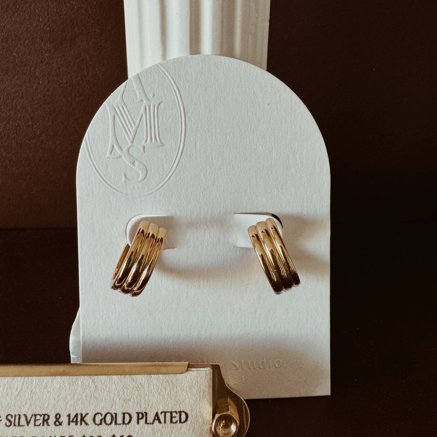 Small gold hoop earrings with ribbed texture and triple hoop design